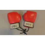 A pair of boxing gloves with an indistinct autograph.
