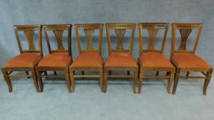 A set of six Anglo Indian teak dining chairs with pierced splat backs. H.96cm