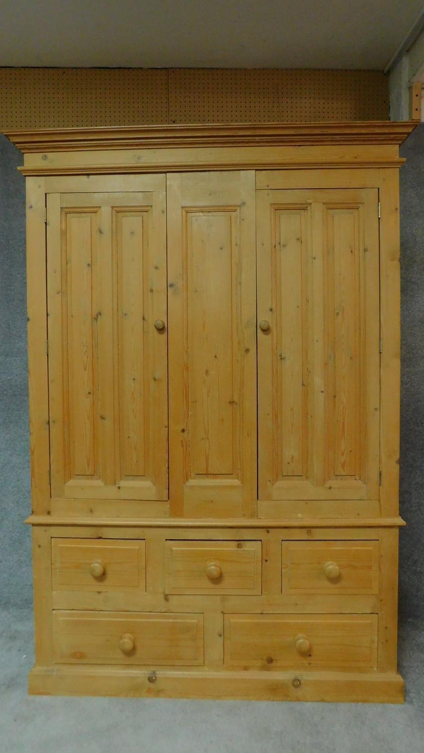A pine Victorian style wardrobe with hanging section above an arrangement of drawers. H.198 W.140