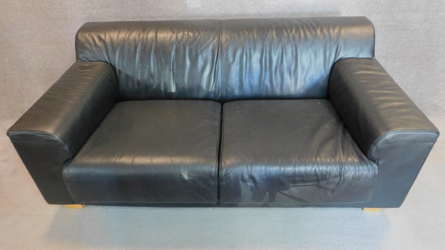 An Italian black leather sofa on solid block feet. 73x177x97cm (bought from Heal's, pair to the