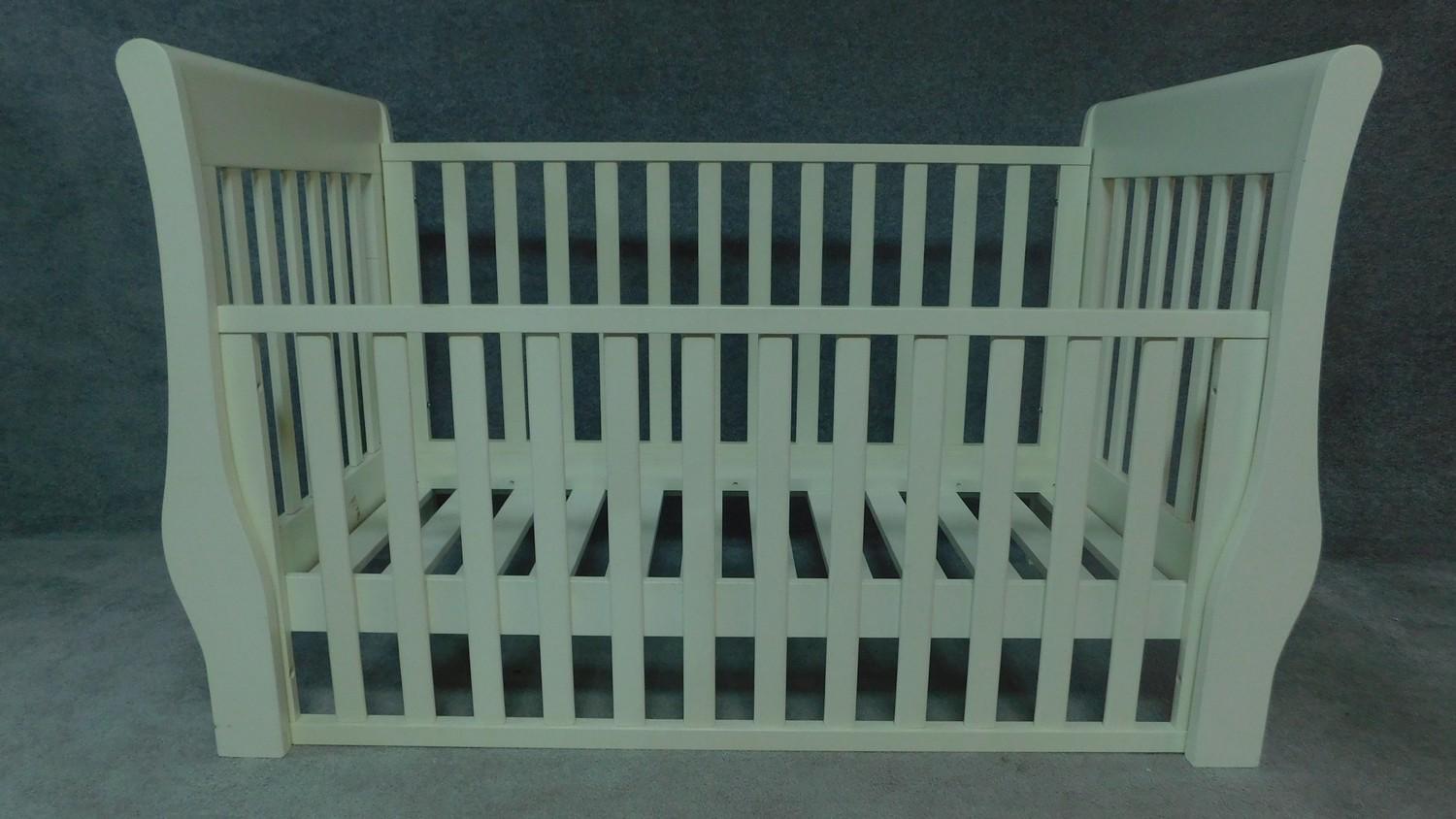 A contemporary white painted child's cot. H.98cm W.140cm D.67cm