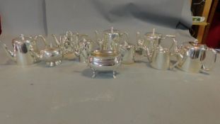 A collection of silver plated tea pots, jugs and sugar bowls.