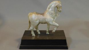 An indian metal mounted figure of a horse on a wooden stand with engraved detailing. Stamped to