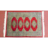 A Turkish rug with 4 pendant medallions on a rouge field surrounded by multiple geometric borders,