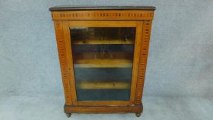 A Victorian walnut and satinwood inlaid pier cabinet with single glazed door. H.104 W.75 D.29