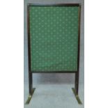 A Regency mahogany fire screen with sliding panels and central glazed drop in section on brass