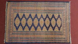 A Bokhara rug on a blue field surrounded by multiple geometric borders 154x98cm