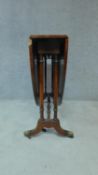 A Regency style mahogany oval drop flap dining table on brass lion paw feet. H.74cm W.138cm D.99cm