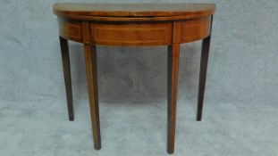 A Georgian mahogany and boxwood strung demi lune card table on square tapering supports. H.74 W.91