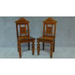 A pair of late Victorian oak hall chairs with walnut crossbanded solid seats. H.97cm