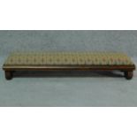 A William lV oak long footstool in original tapestry upholstery on scroll end supports. H.16 W.86