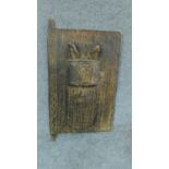 A peg hinged door with tribal face carving. H. 61cm W. 34cm