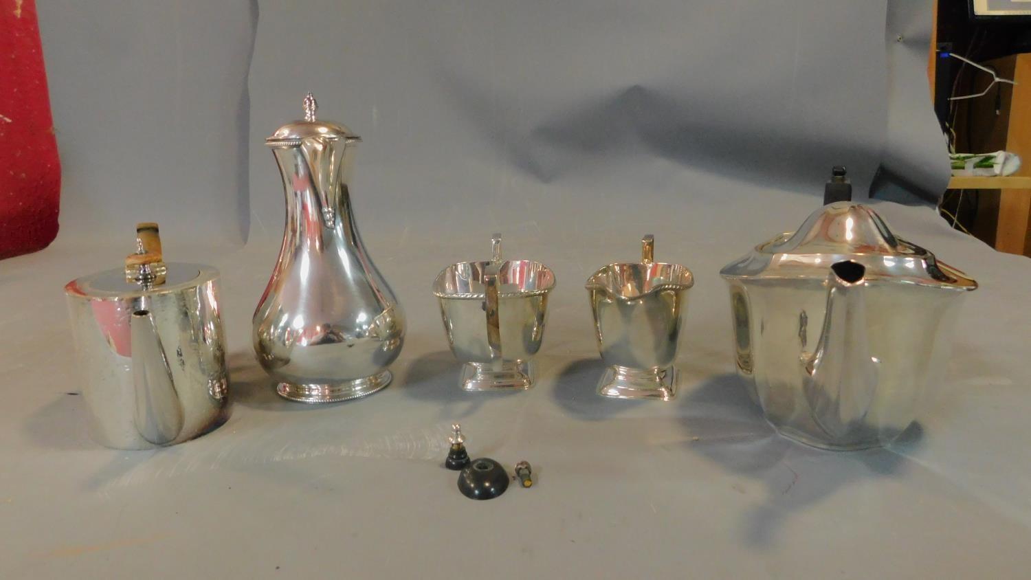 A collection of silver plated jugs and tea pots.