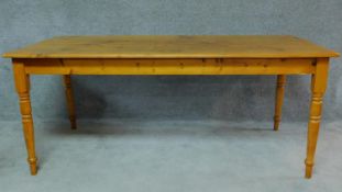 A 19th century pine/yellowwood planked top refectory dining table on turned tapering supports. H.