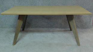 A contemporary limed oak planked top dining table on stained splay supports. H.75 W.180 D.95cm