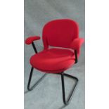 A Herman Miller metal framed office armchair in red upholstery. H.84cm