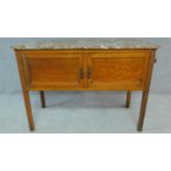 An Edwardian oak two door marble topped washstand. H.77 W.108 D.47cm