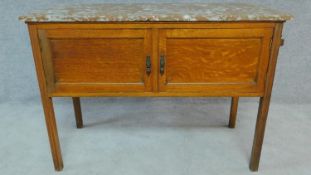 An Edwardian oak two door marble topped washstand. H.77 W.108 D.47cm