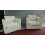 A pair of armchairs upholstered in cream, makers label to base. H.79cm
