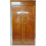 An early 19th century plum pudding mahogany hall cupboard fitted with panel doors enclosing