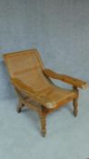 A colonial teak framed reclining planter's chair with foldout foot rests on turned tapering