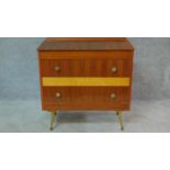 A vintage 1960's teak and satin birch inlaid chest of two long drawers on sputnik style supports.