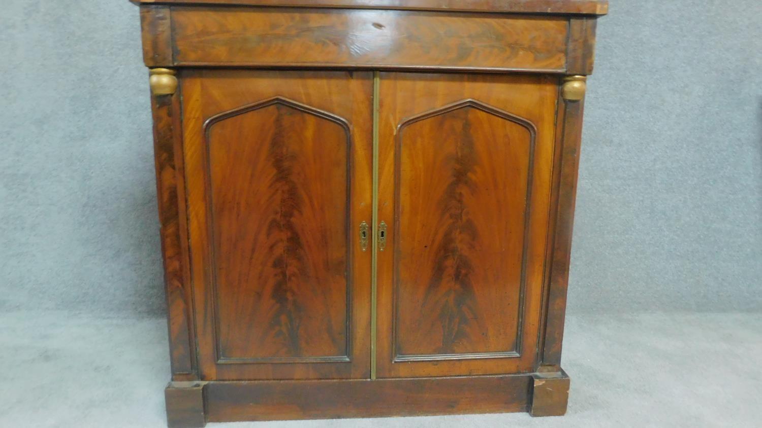 A Regency mahogany two door chiffonier with arched panel doors flanked by pilasters. H.92cm W.92cm