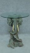 A glass topped occasional table on moulded elephant base. H.63 W.51cm