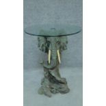 A glass topped occasional table on moulded elephant base. H.63 W.51cm