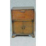 A vintage 1950's oak two door cabinet with drop flap upper section. H.71 W.54 D.37cm