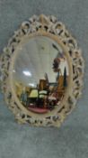 A carved and limed oak Florentine style wall mirror. H.84cm W.64cm