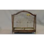 A Victorian style wooden bird cage with exotic birds on perches with wire bars and metal carrying