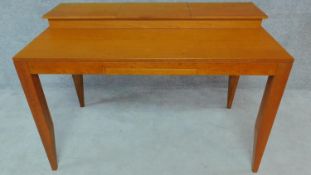 A teak Heal's writing desk with fitted superstructure on square tapering supports. H.80 W.121 D.66cm