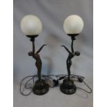 A pair of Art Deco style resin lamps of dancing ladies with crackle glass frosted globe shades. H 67