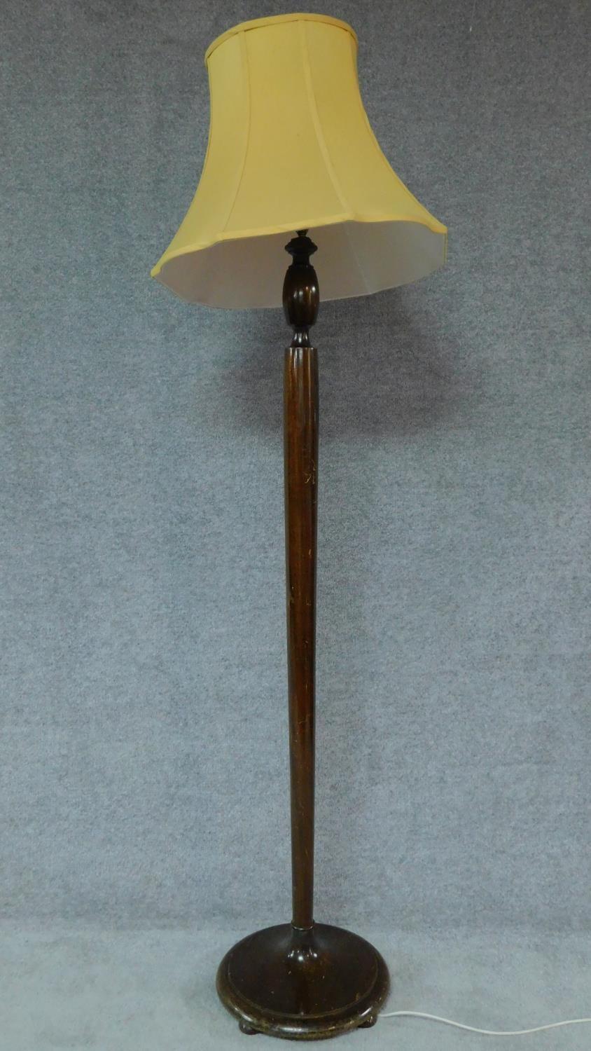 A mid 20th century teak standard lamp with lemon shade. H.180