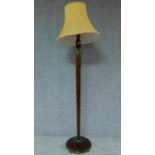 A mid 20th century teak standard lamp with lemon shade. H.180