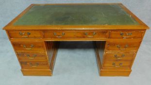 A Georgian style three section yew pedestal desk with green tooled leather inset top and an