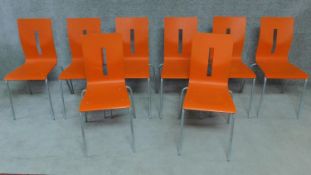 A set of eight orange painted plywood stacking chairs by allermuir. H.87cm