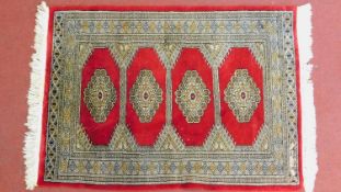A Turkish rug with 4 pendant medallions on a rouge field surrounded by multiple geometric borders,