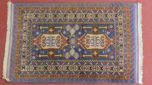 A Persian Hamadan style rug, with double central medallions on a sapphire field, within geometric