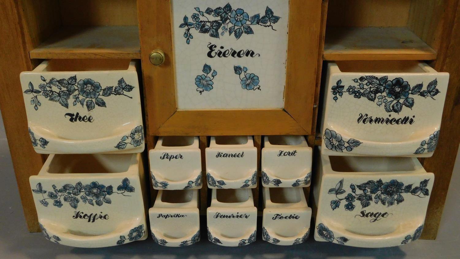 A vintage Dutch herb and spice cabinet with ceramic drawers and door and wooden frame. Central - Image 2 of 3