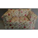 A floral upholstered two seater sofa. 74x160x88cm