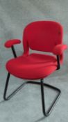 A Herman Miller metal framed office armchair in red upholstery. H.84cm