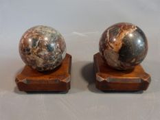 A pair of Victorian Italian marble carpet bowls on carved walnut stands with four button feet to