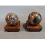 A pair of Victorian Italian marble carpet bowls on carved walnut stands with four button feet to