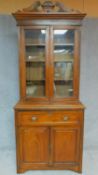 A Victorian walnut two section library bookcase with upper glazed section above panel doors and well