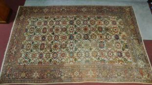A Persian Tabriz rug with allover floral motifs on a cream ground within floral multi borders