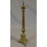 An antique brass Gothic style pricket candle stick. H.61cm