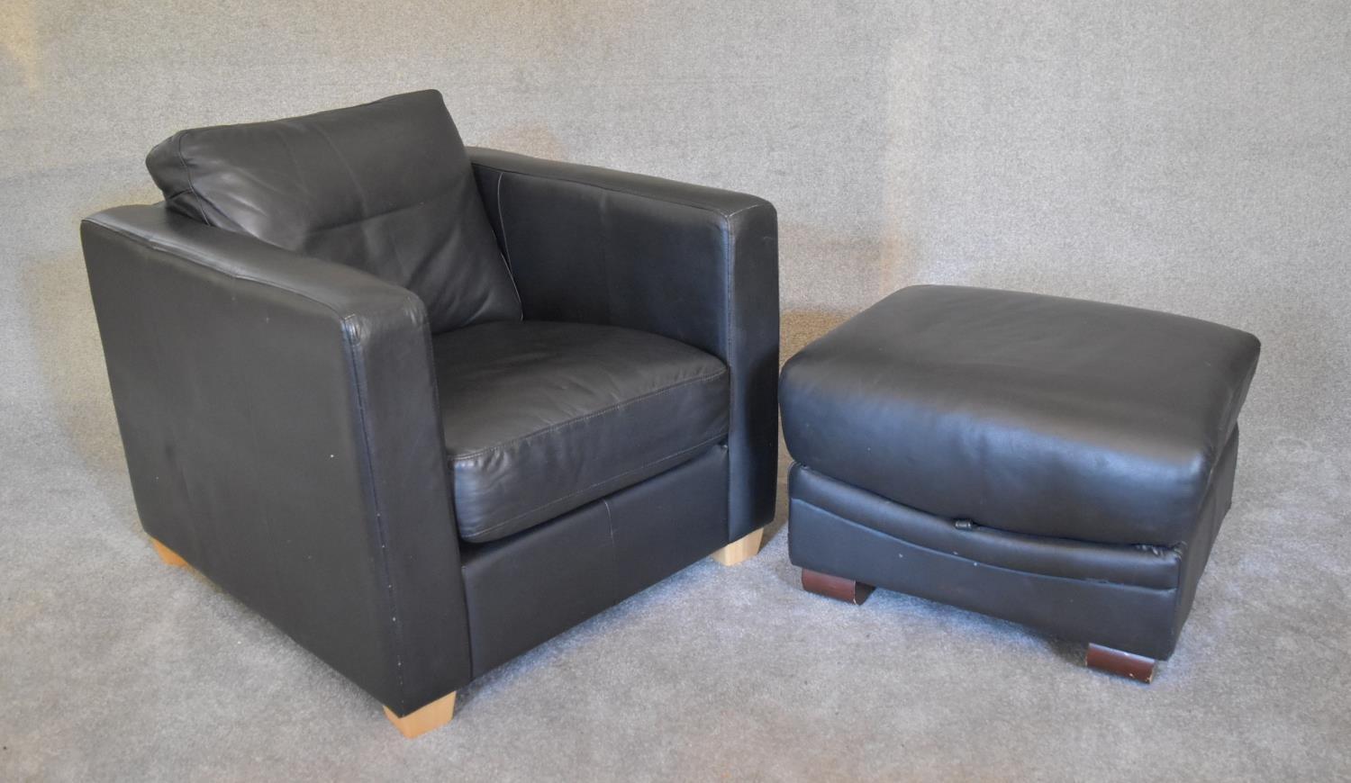 A black leather armchair with matching footstool. Chair: H. 67 x 80cm stool: H.44 x 70cm