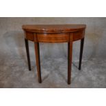 A Georgian mahogany and satinwood inlaid foldover top demi lune card table. H.74 x 92cm